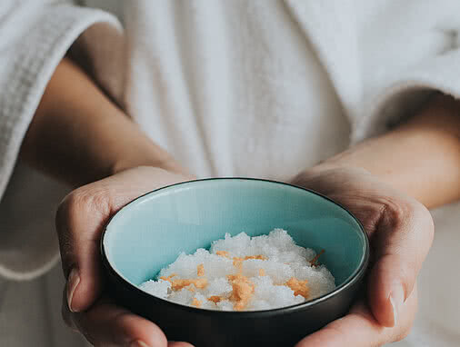Rezept Orangen-Salz-Peeling Tauernhof Großarl: Zwei Händel halten eine Schüssel mit dem Orangen-Salz-Peeling darin.