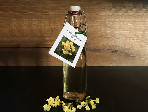 Rezept Schlüsselblumensirup Tauernhof Großarl: Eine Flasche mit Bügelverschluss gefüllt mit dem Sirup.