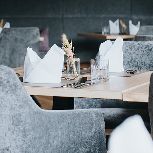 gedeckte Tische im Speiseraum im Tauernhof Restaurant