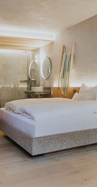 Bett im Zimmer Kräuter&Kammerl in der Unterkunft Hotel Tauernhof in Großarl