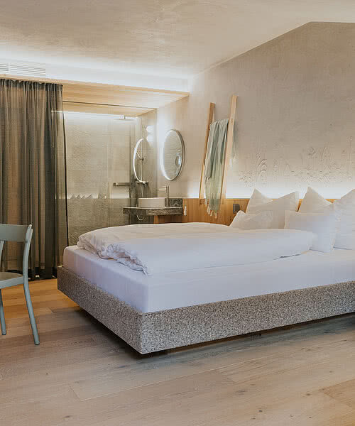 Bett im Zimmer Kräuter&Kammerl in der Unterkunft Hotel Tauernhof in Großarl