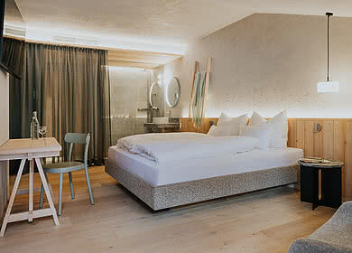 Bett im Zimmer Kräuter&Kammerl in der Unterkunft Hotel Tauernhof in Großarl