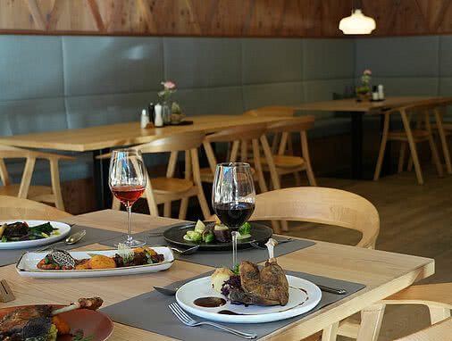 Das Restaurant des Tauernhofs ist eingedeckt und es befinden sich Speißen auf einem Tisch.