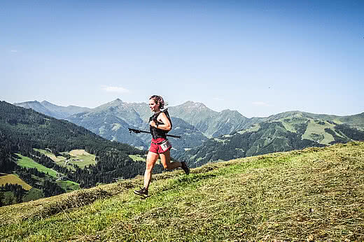 Trail Läuferin beim Mountainman Großarl vor sommerlicher Bergkulisse