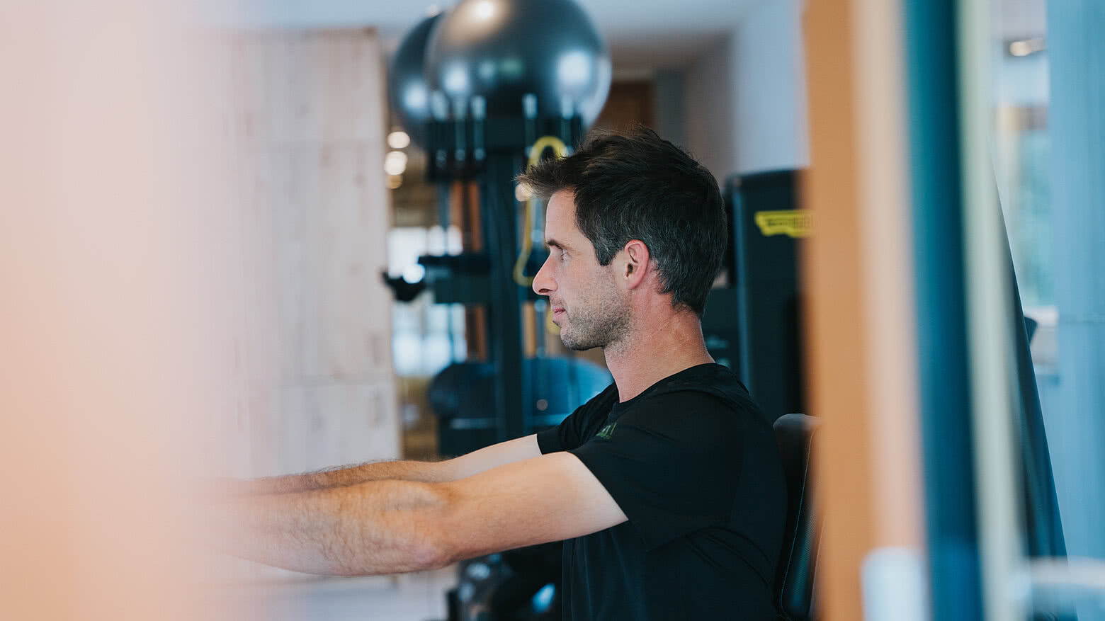 Mann beim Trainieren im Fitnessraum im Hotel Tauernhof