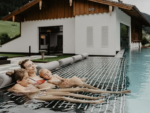 Mutter mit Kindern beim Relaxen im Outdoor Pool