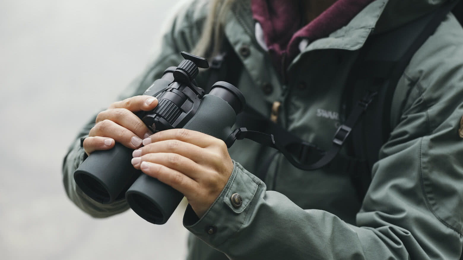 Frau mit einem Swarovski Optik Fernglas