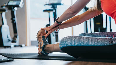 Frau beim Dehnen im Fitnessraum vom Hotel Tauernhof
