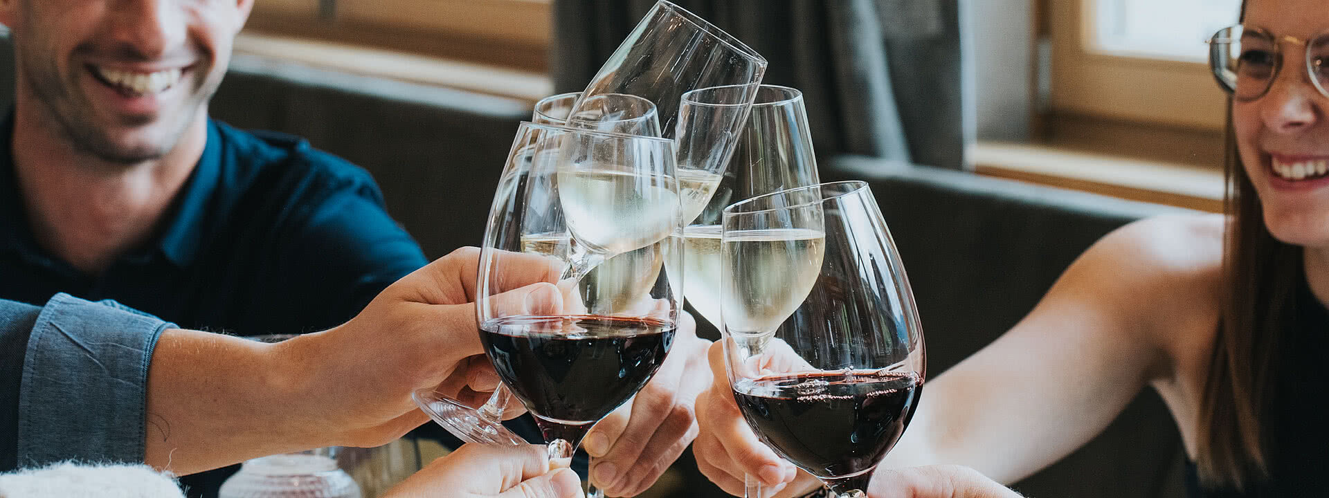 Gruppe stoßen beim Essen mit Wein an