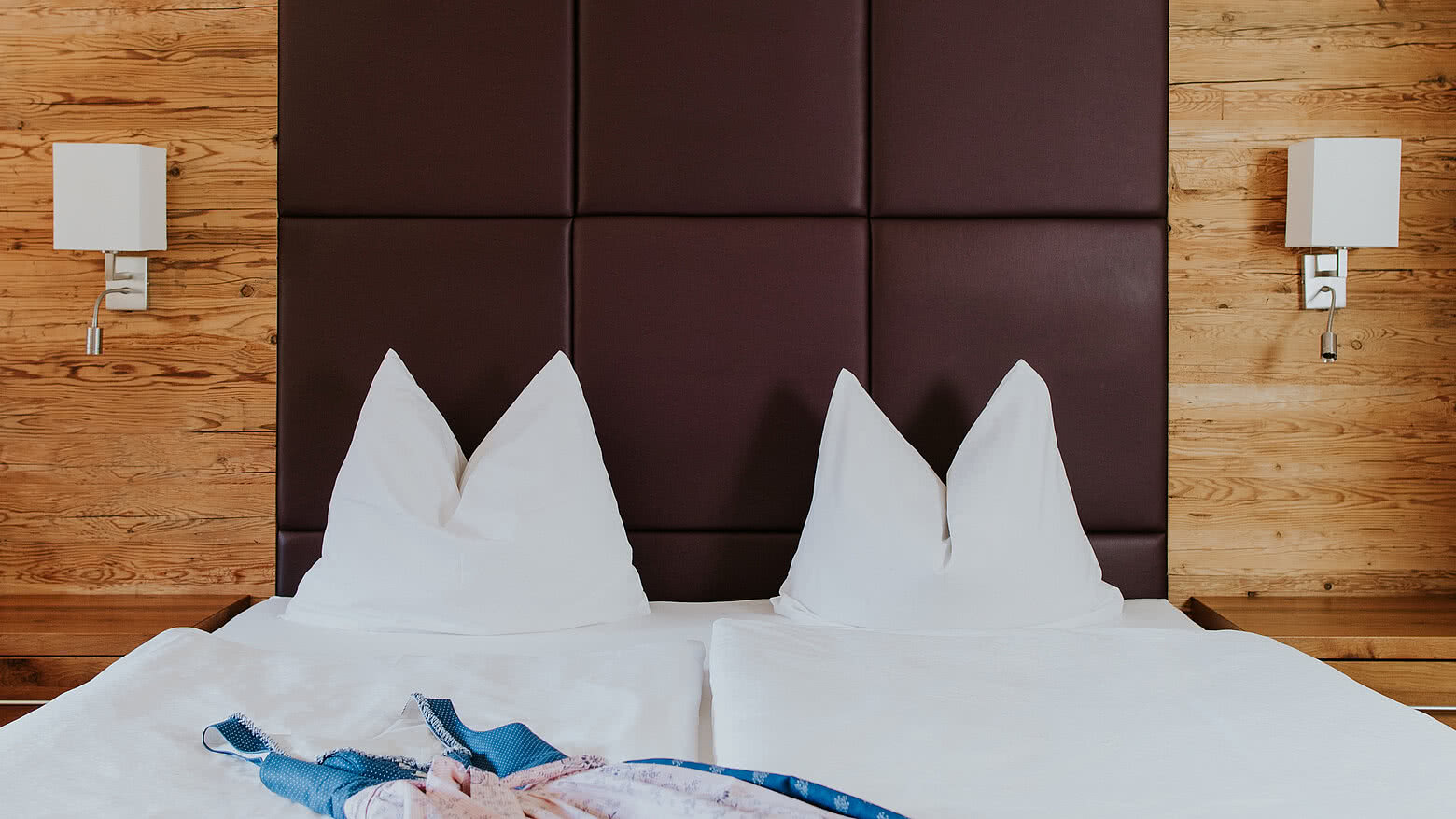 Bed in an Alpine apartment room in the Hotel Tauernhof in Großarl